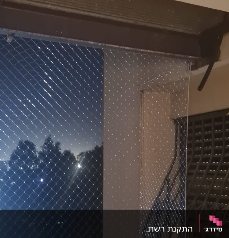רשת מתוחה על חלון למניעת כניסת יונים